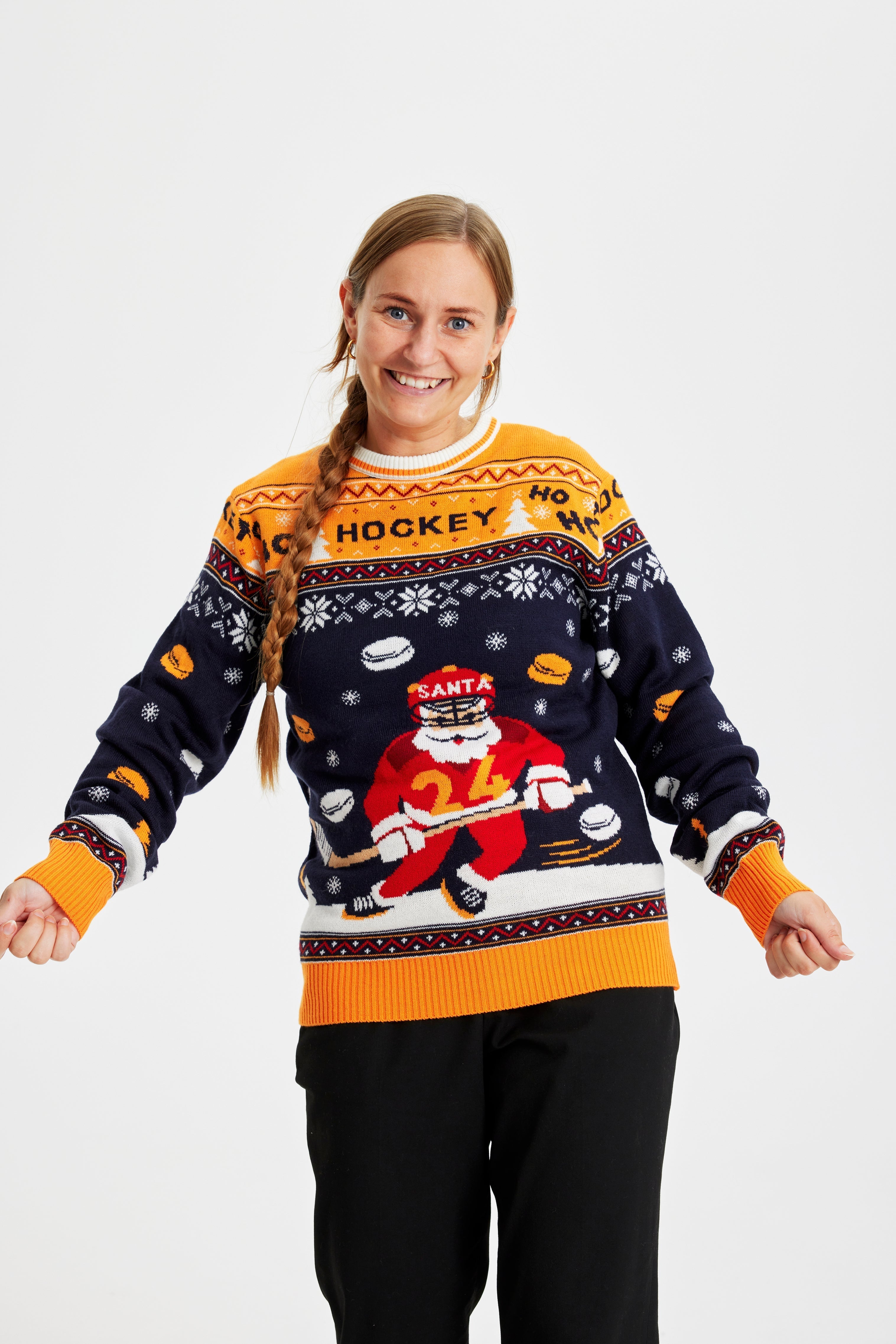 En kvinna i jultröja med en jultomte som spelar hockey.